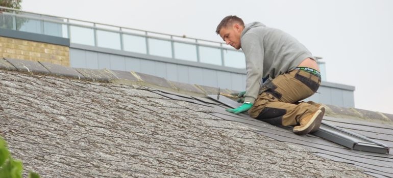 A man putting roof tiles